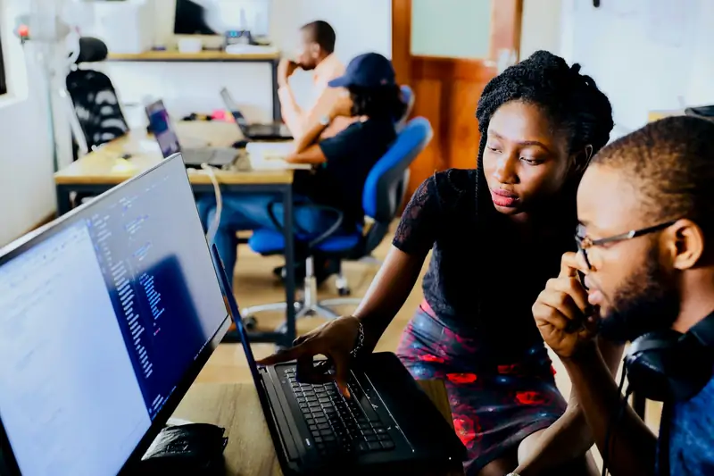 Colleagues working together at a computer in an office